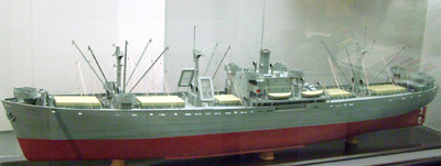 A model of a long grey ship with a red hull