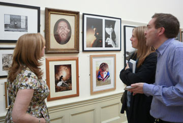 people discussing paintings on a gallery wall