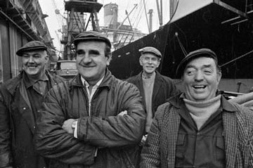 old photo of smiling dockers wearing flat caps