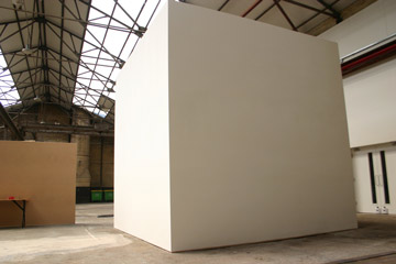 Large white cube in a warehouse