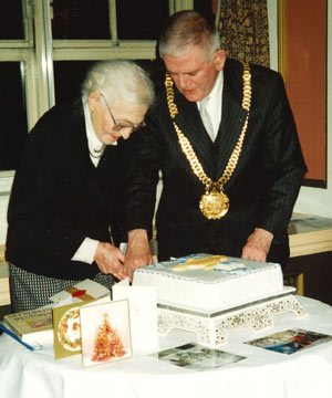 man and woman cutting a large cake