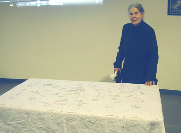 woman with a tablecloth embroidered with names