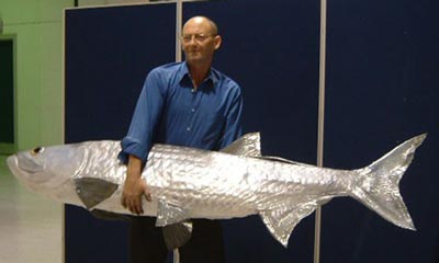 Taxidermist holding a mounted specimen of a large fish