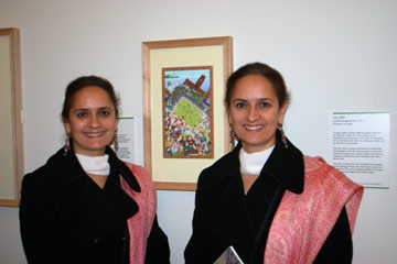 Two women next to a small painting