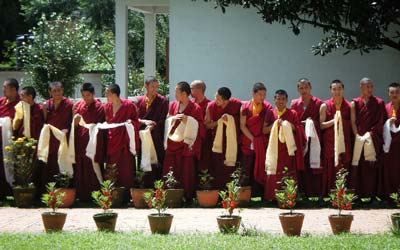 Monks standing in a row holding scarves