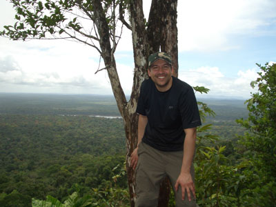 Richard on top of a mountain overlooking a green landscape