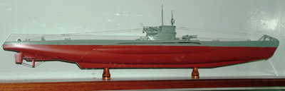 model of a long warship with a red hull and grey decks