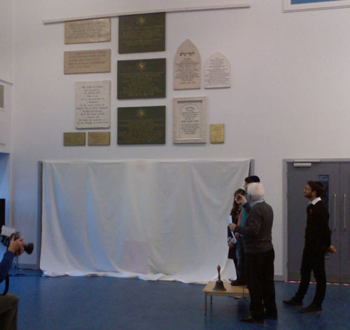 wall of plaques being revealed from behind a curtain