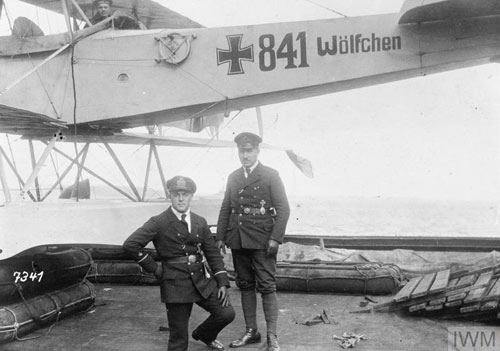 Men in uniform standing in front of a small plane