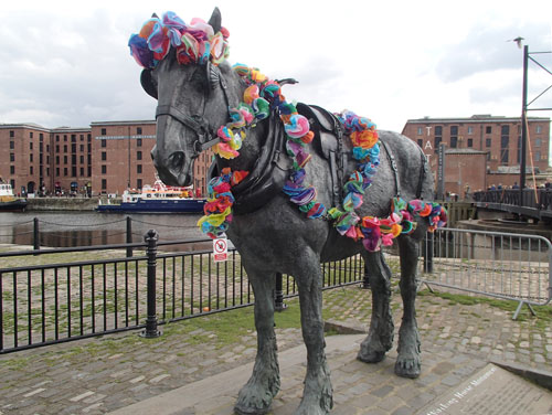 horse statue with garlands of paper flowers draped around it