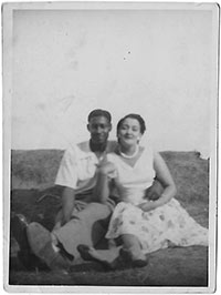 Young man and woman sitting with their arms round each other