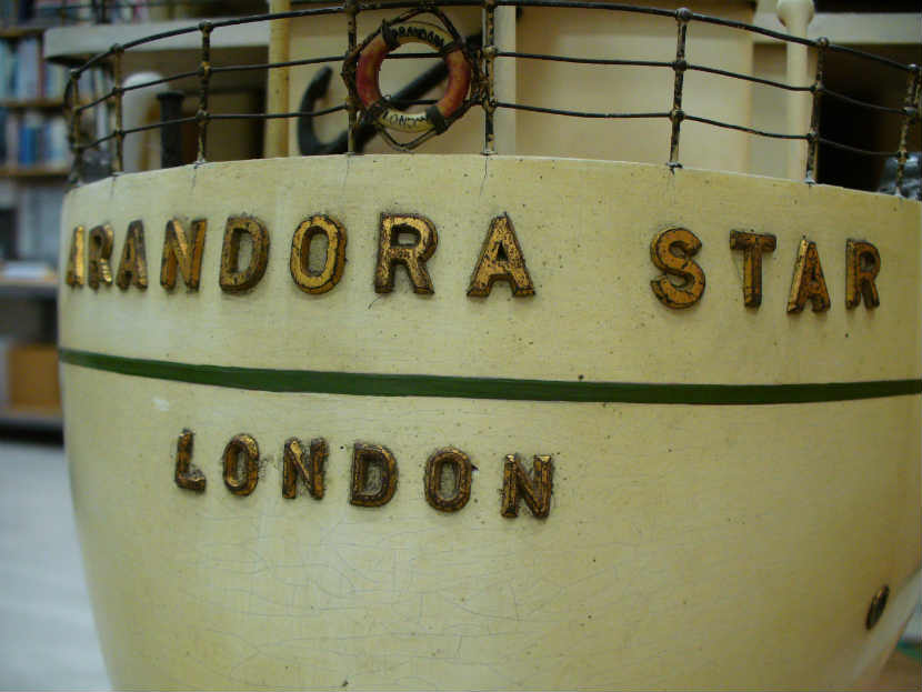 detail of name 'Arandora Star, London' on ship model, showing decay and water damage