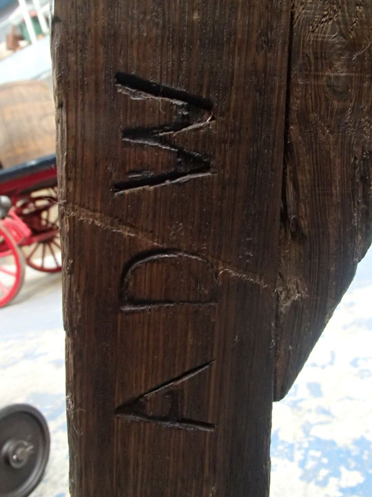 detail of 'ADW' carved into wooden cart