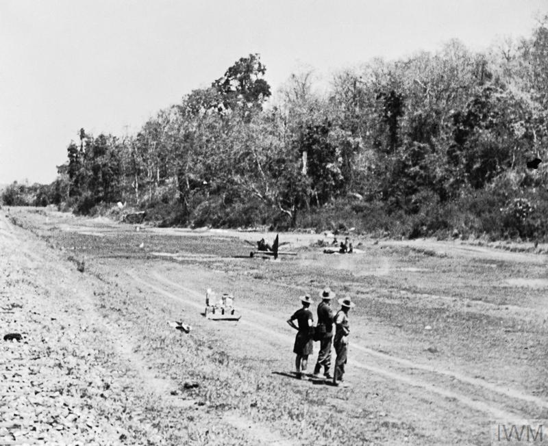 soldiers by strip of land cleared as a landing strip for planes