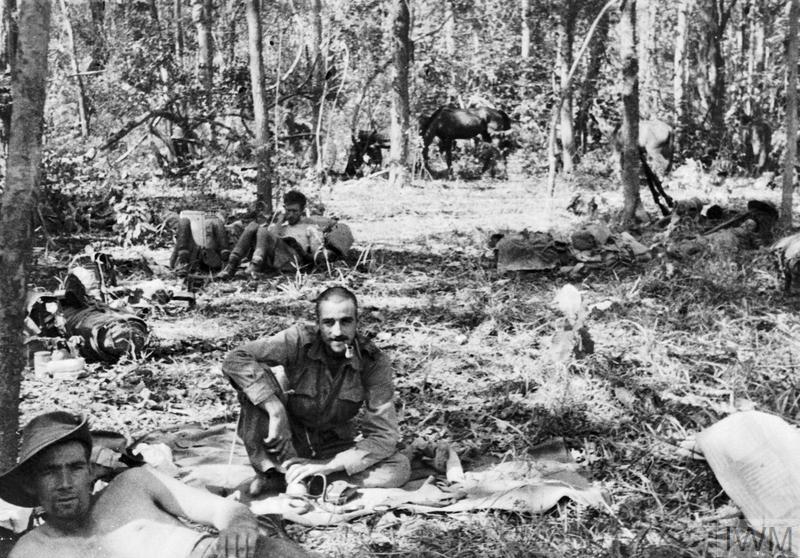 Soldiers sitting around a jungle clearing
