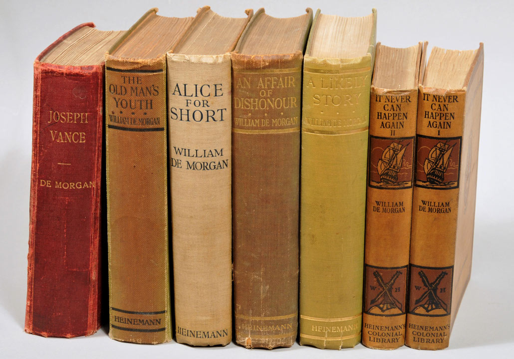 Seven old hardback books, all written by De Morgan