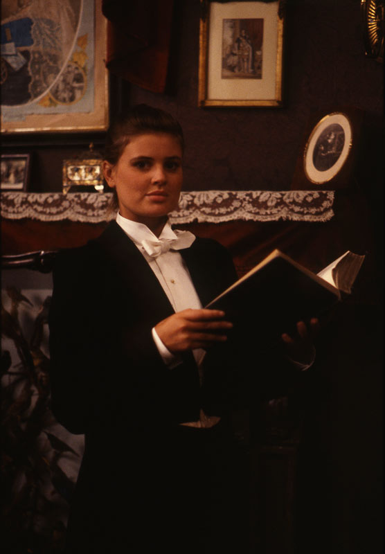 Doctor Who character Ace wearing a tuxedo and holding a book