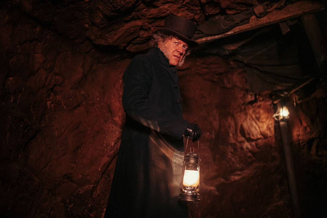 Actor dressed as Joseph Williamson, with smart 19th century clothing, in a tunnel