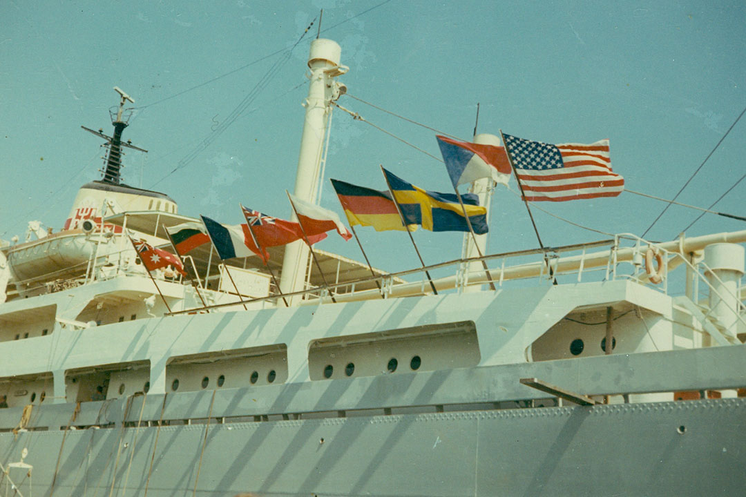 Flags of different nations flying on the side of a ship