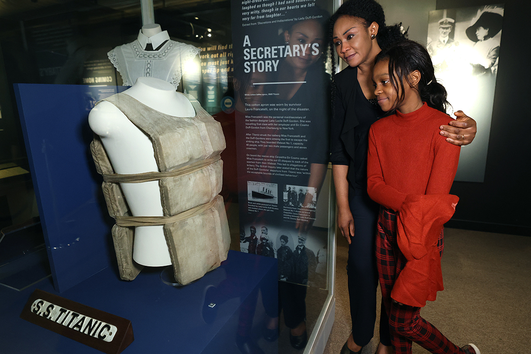 Mother and daughter looking at Titanic life jacket