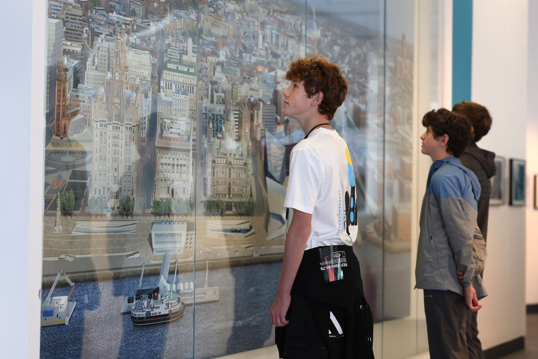 Boys looking at a huge and highly detailed painting of modern Liverpool