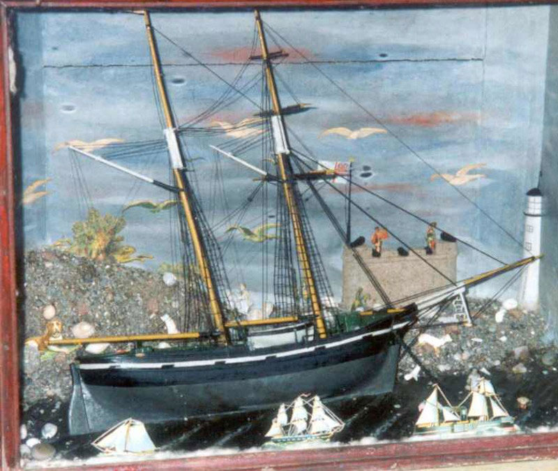 framed diorama of a sailing ship with a lighthouse, castle and other much smaller ships