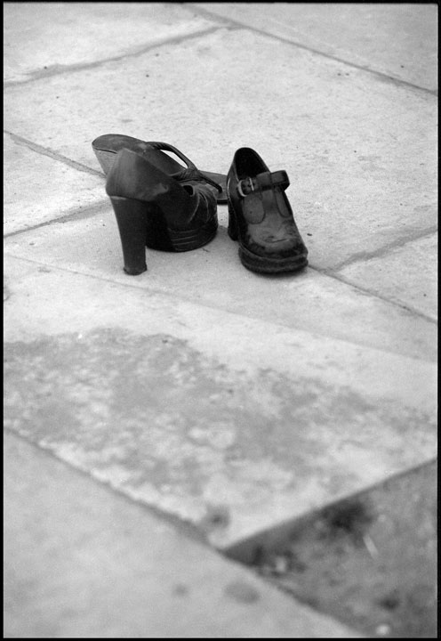Three abandoned high heeled shoes on the pavement