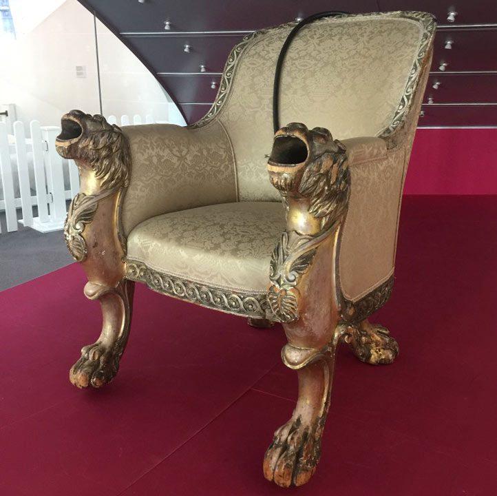 ornate chair with hearing device and speakers shaped like roaring lions