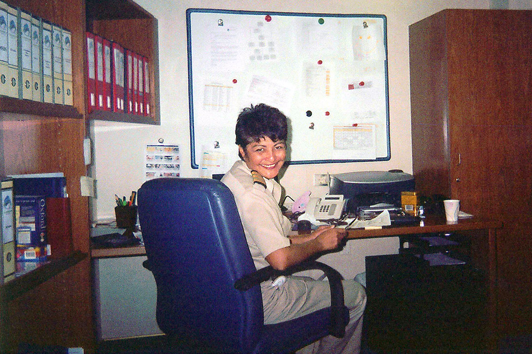 Fazilette sat at a desk in an office, wearing a boiler suit