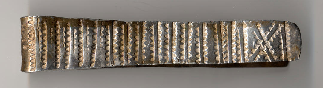 Flattened silver band with pattern stamped into the surface