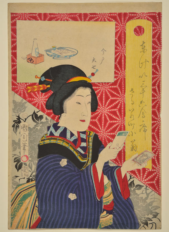 Japanese woman in traditional dress holding a small photograph in each hand
