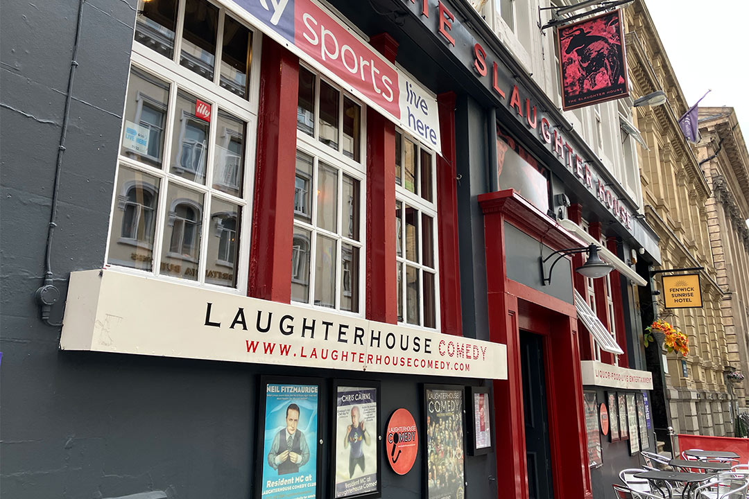 The Slaughterhouse pub with promotional posters for comedy nights under a sign saying Laughterhouse