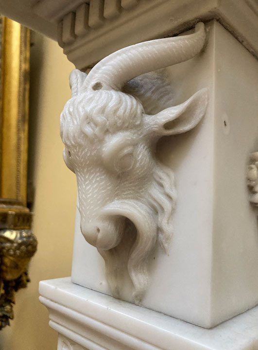 goat's head carved in marble mantelpiece