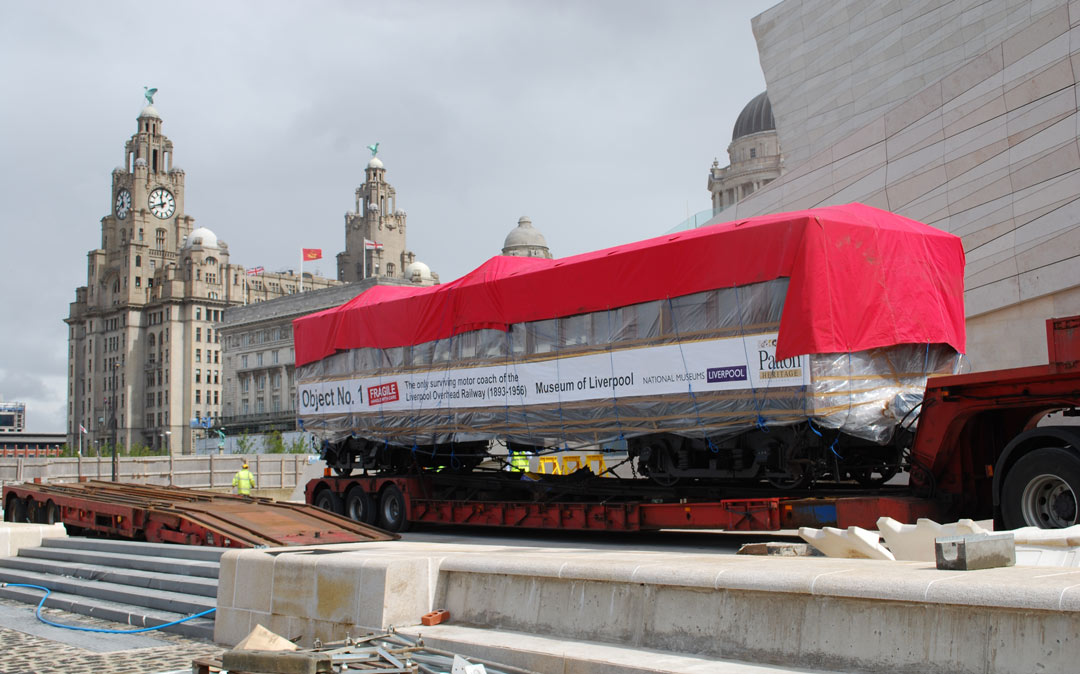 railway carriage on a truck with Liver Building in the background