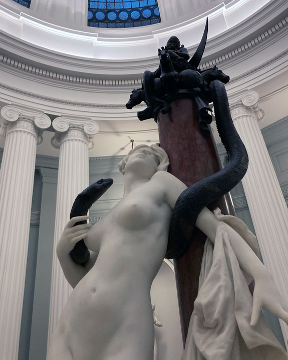 sculpture of a woman with a snake coiled around her