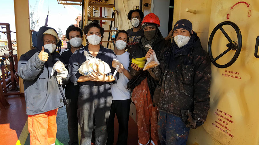 seafarers wearing protective masks, holding food