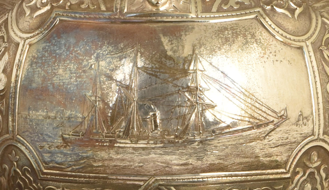 detail of ship in calm water on tarnished silver cup