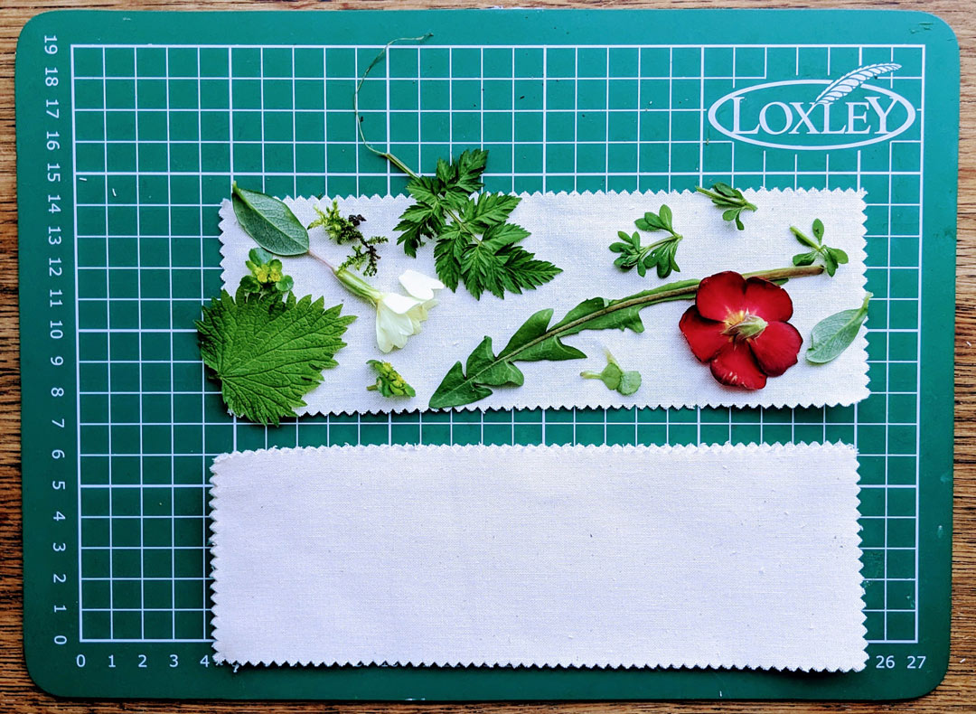flowers and leaves arranged on a strip of fabric on a cutting board