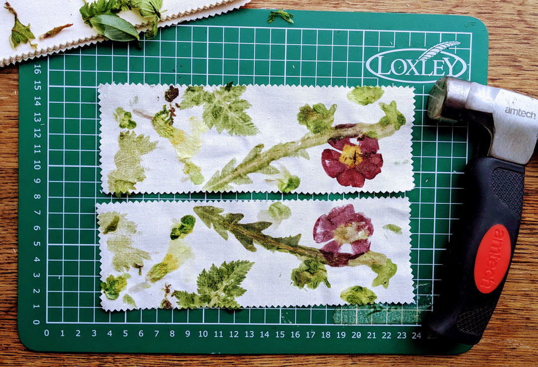 2 fabric strips with mirror image prints of flowers and leaves, on a cutting board by a hammer